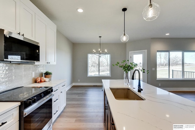 kitchen featuring white cabinetry, light stone countertops, sink, and electric stove