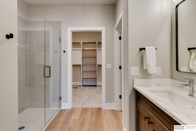 bathroom featuring vanity, hardwood / wood-style floors, and a shower with shower door