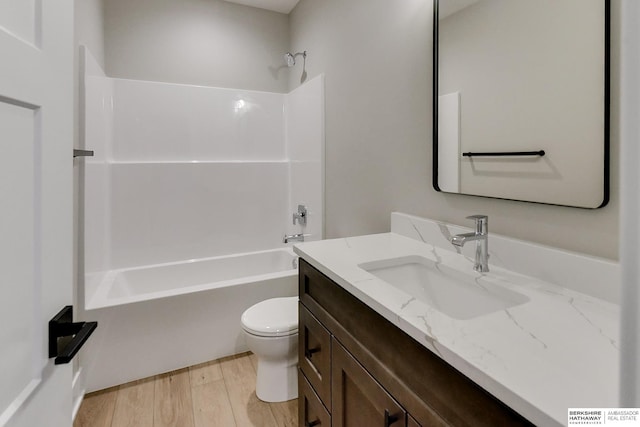 full bathroom with shower / bathing tub combination, vanity, wood-type flooring, and toilet