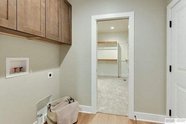 laundry room with cabinets, washer hookup, hookup for an electric dryer, and light wood-type flooring