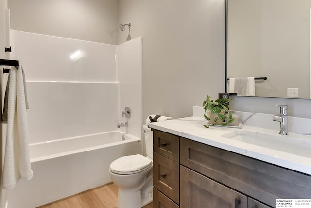 full bathroom featuring vanity, hardwood / wood-style flooring, shower / tub combination, and toilet