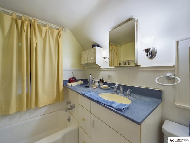 bathroom with lofted ceiling, vanity, and toilet