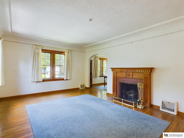 unfurnished living room with hardwood / wood-style floors and a tile fireplace