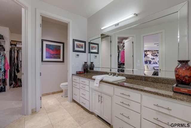 bathroom featuring vanity, tile patterned floors, and toilet