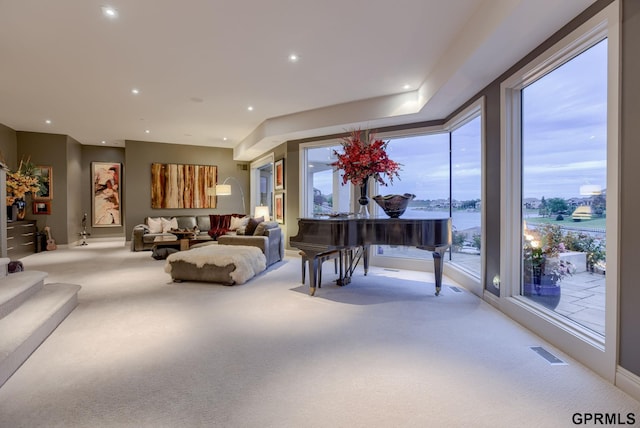 living room featuring a water view and light carpet