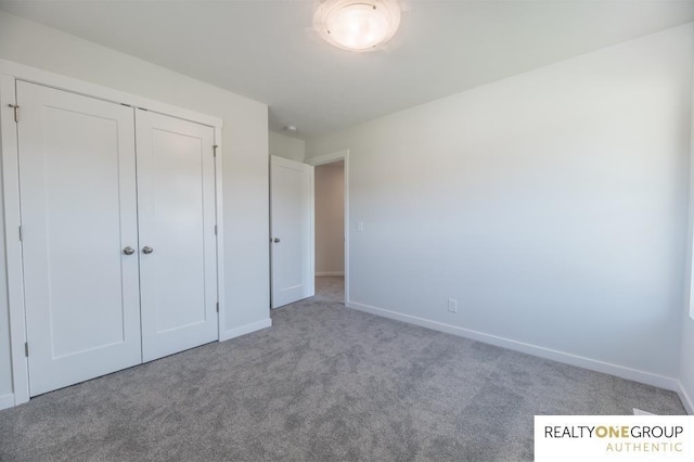 unfurnished bedroom with light carpet and a closet