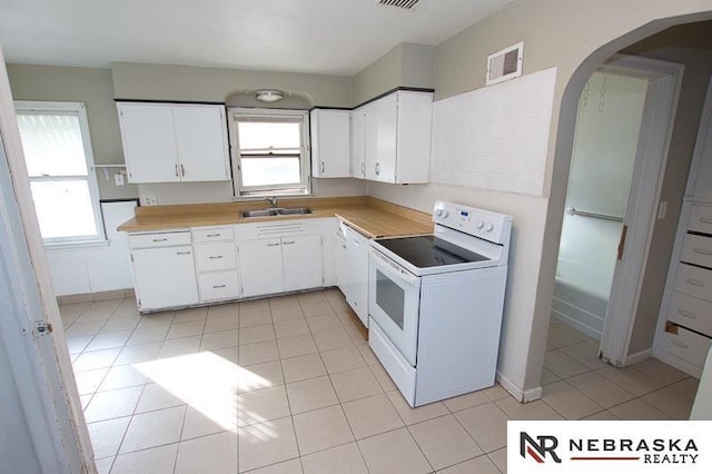 kitchen featuring white cabinetry, sink, light tile patterned flooring, and white appliances