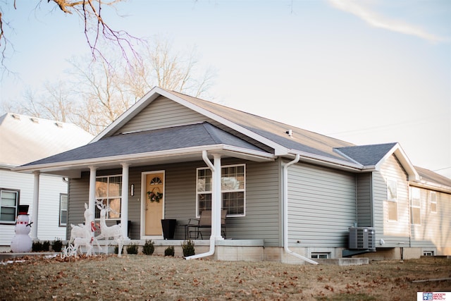 bungalow-style home featuring a porch and central AC unit