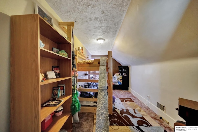 interior space with vaulted ceiling and a textured ceiling