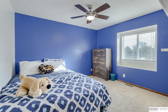 bedroom with a textured ceiling, ceiling fan, and carpet flooring