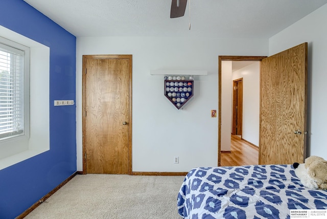 carpeted bedroom with multiple windows, a textured ceiling, and ceiling fan