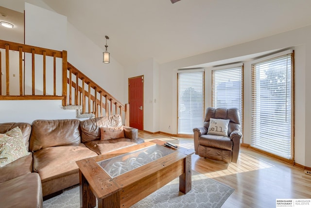 living room with light hardwood / wood-style flooring and vaulted ceiling