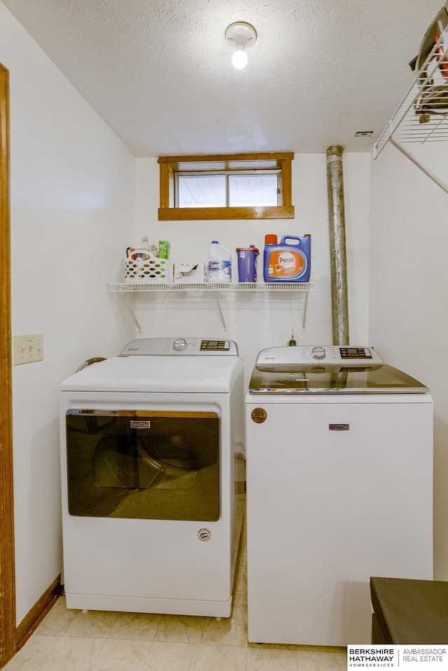 washroom featuring washer and clothes dryer and a textured ceiling