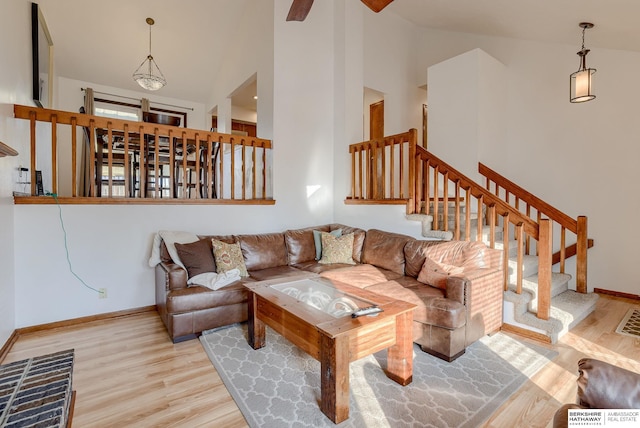 living room with high vaulted ceiling and light wood-type flooring