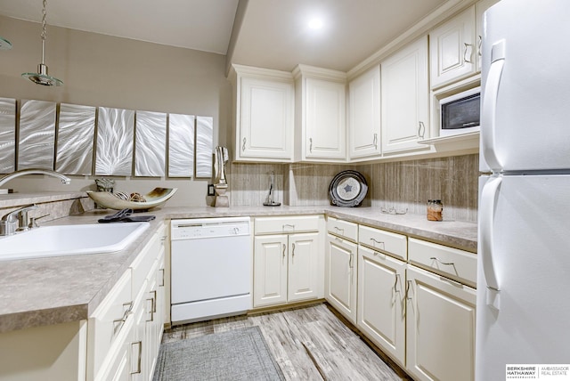 kitchen with sink, tasteful backsplash, light wood-type flooring, white appliances, and white cabinets