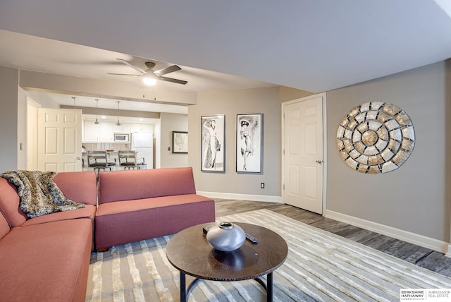 living room with light hardwood / wood-style floors and ceiling fan