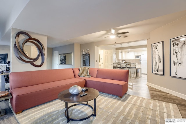 living room with ceiling fan and light hardwood / wood-style flooring