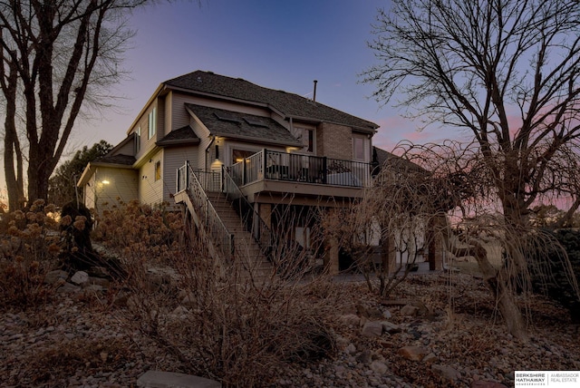 back house at dusk with a wooden deck