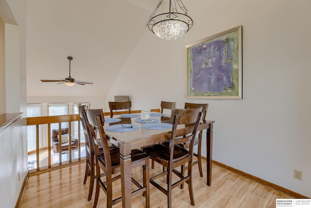 dining space featuring ceiling fan with notable chandelier, lofted ceiling, and light hardwood / wood-style floors