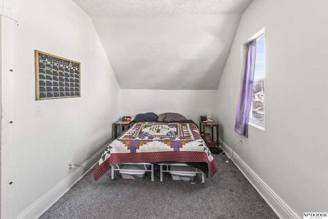 bedroom featuring lofted ceiling, carpet floors, and a textured ceiling