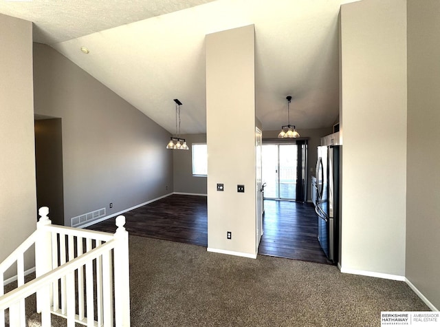 interior space featuring dark colored carpet and lofted ceiling