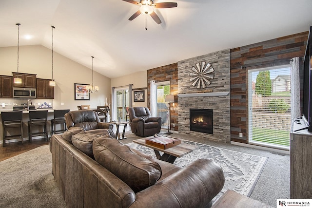 carpeted living room with a fireplace, ceiling fan with notable chandelier, plenty of natural light, and sink