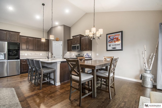 dining area featuring an inviting chandelier, sink, dark hardwood / wood-style floors, and high vaulted ceiling