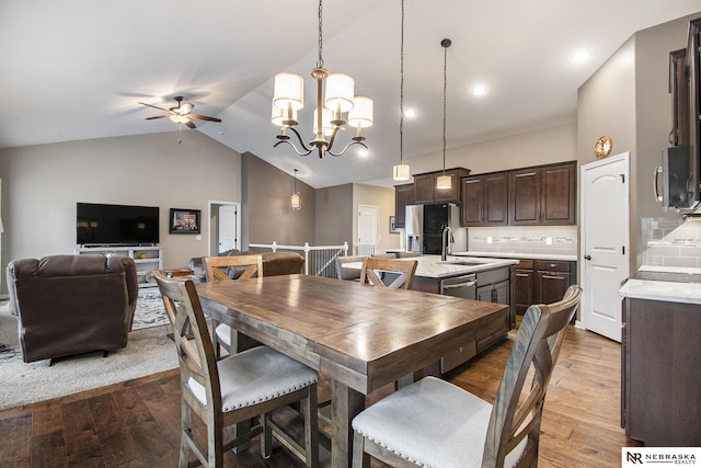 dining room with lofted ceiling, sink, hardwood / wood-style flooring, and ceiling fan