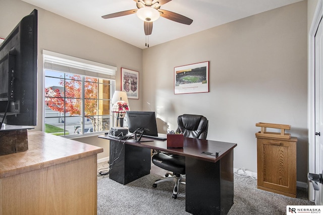 carpeted office space featuring ceiling fan