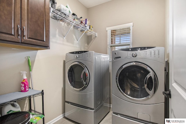 washroom featuring cabinets and washer and clothes dryer