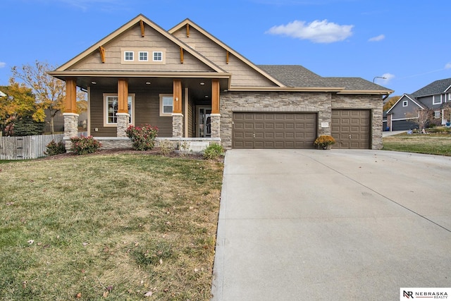 view of front of property with a garage, a front lawn, and a porch