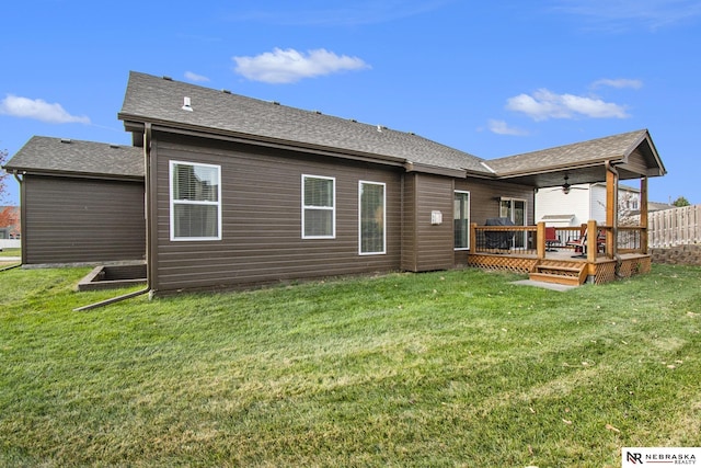 back of house with a wooden deck, ceiling fan, and a lawn