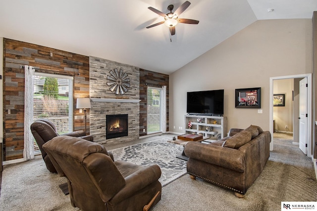 carpeted living room featuring ceiling fan, a tiled fireplace, and vaulted ceiling