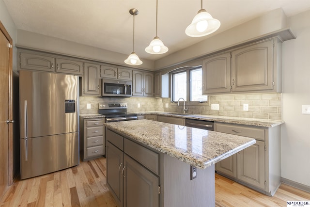 kitchen with stainless steel appliances, decorative light fixtures, a center island, and backsplash