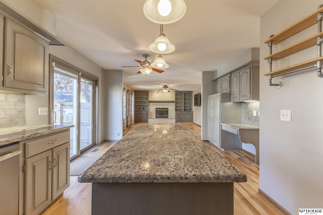 kitchen featuring tasteful backsplash, dishwasher, a center island, and light hardwood / wood-style floors