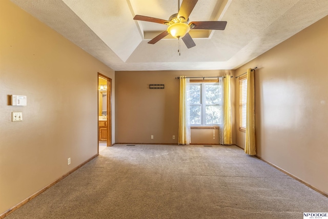 carpeted empty room featuring ceiling fan, a tray ceiling, and a textured ceiling