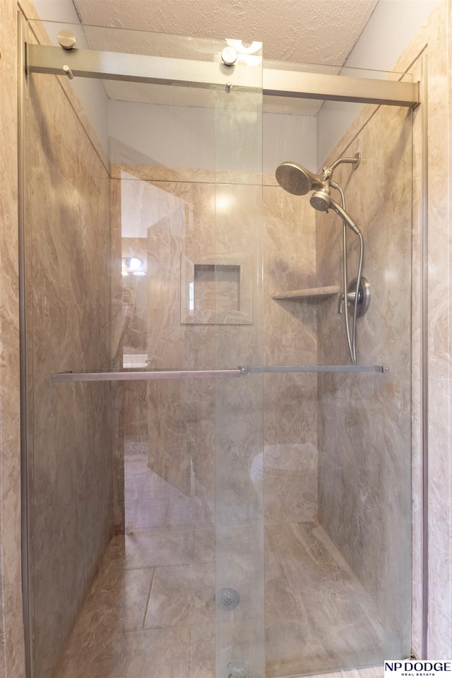 bathroom featuring an enclosed shower and a textured ceiling