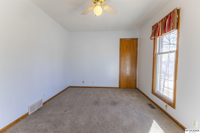 spare room with ceiling fan and light carpet