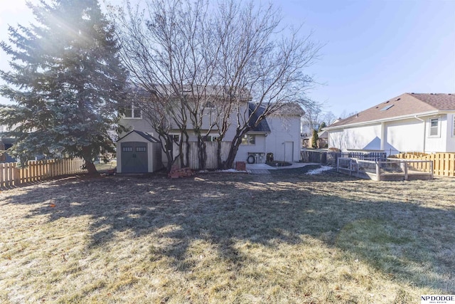 back of house with a lawn and a storage unit