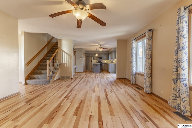 unfurnished living room featuring ceiling fan and light hardwood / wood-style floors