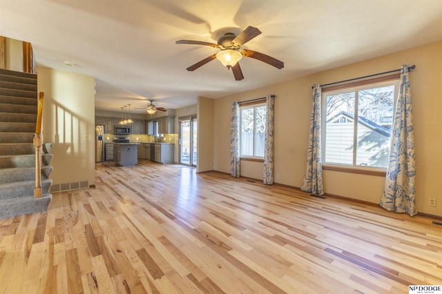 unfurnished living room with ceiling fan and light hardwood / wood-style floors