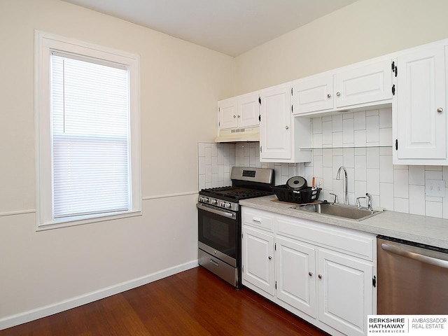 kitchen with sink, dark wood-type flooring, backsplash, stainless steel appliances, and white cabinets