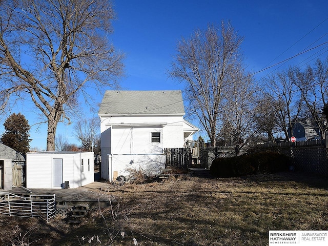 rear view of house featuring a shed