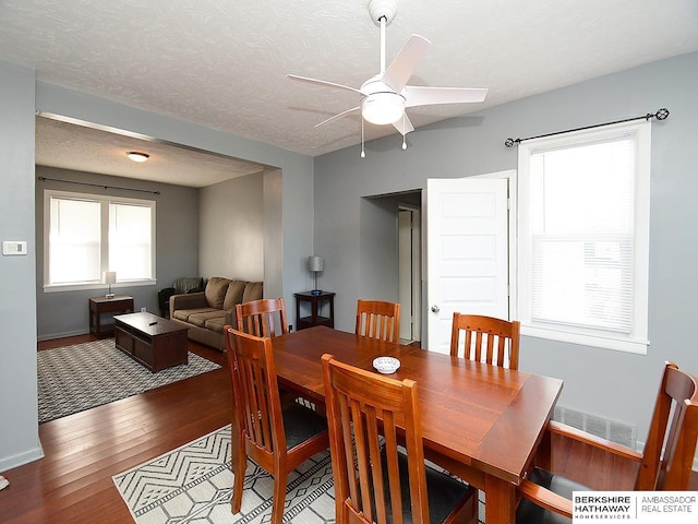 dining space with ceiling fan, plenty of natural light, hardwood / wood-style floors, and a textured ceiling