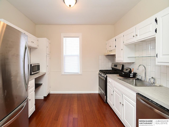 kitchen featuring sink, white cabinets, dark hardwood / wood-style flooring, backsplash, and stainless steel appliances