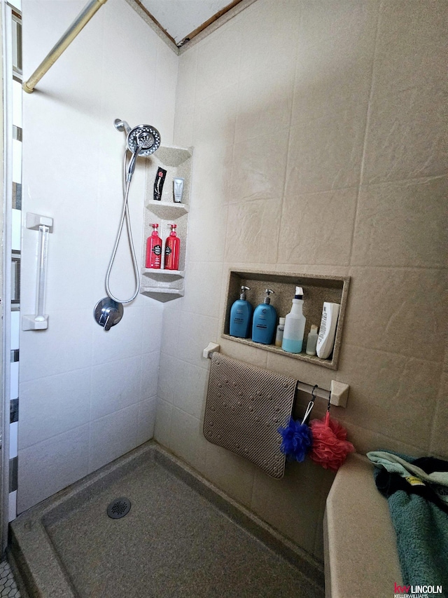 bathroom featuring a tile shower and tile walls