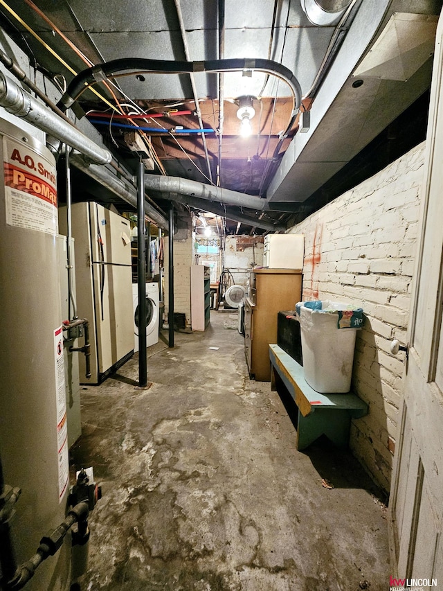 unfinished basement featuring water heater, washer / clothes dryer, and freestanding refrigerator