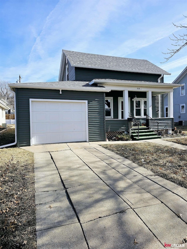 view of front of house with a garage, a shingled roof, a porch, and concrete driveway