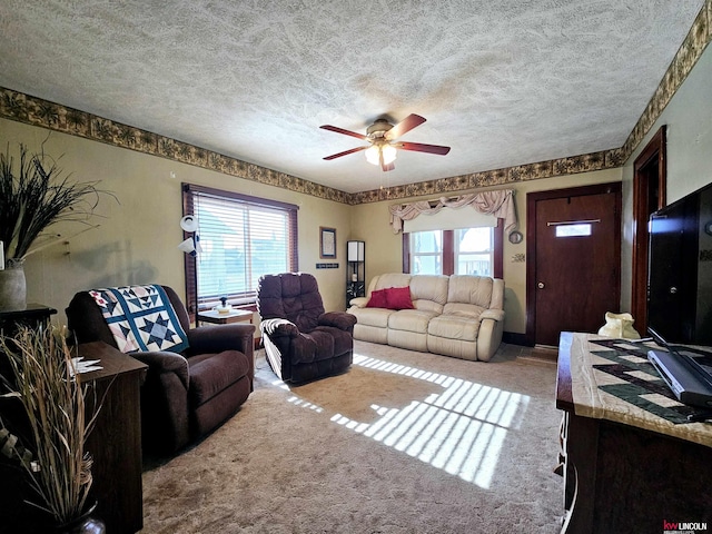 living room with a healthy amount of sunlight, ceiling fan, light carpet, and a textured ceiling