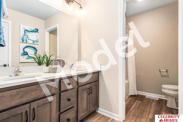 full bathroom featuring hardwood / wood-style flooring, vanity, toilet, and shower / tub combo